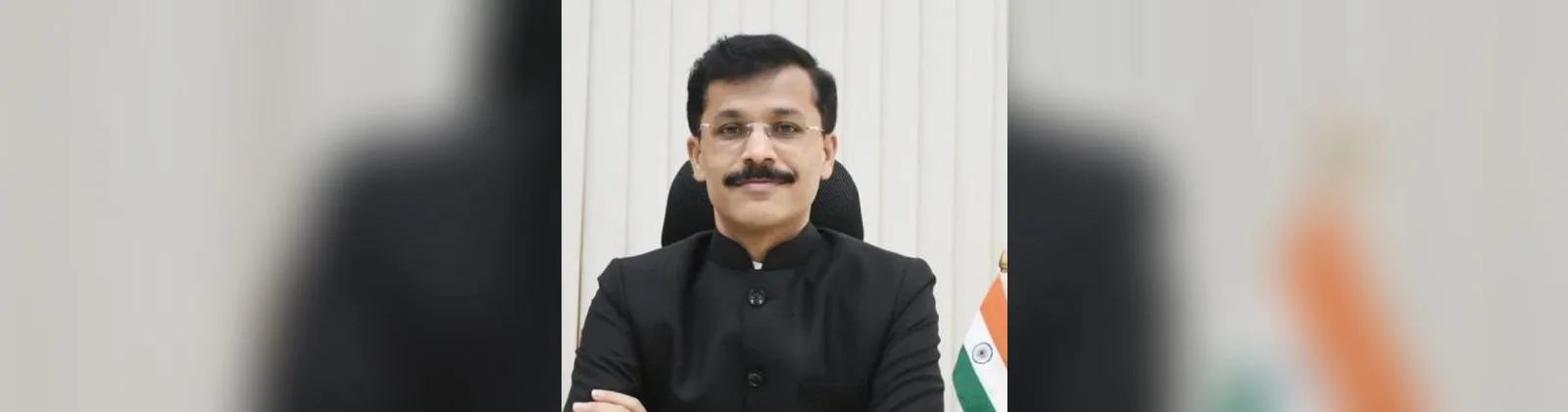काळा बंद गळ्याचा कोट घालून, कार्यालयातील टेबलावर हाताची घडी घालून बसलेले अन्न व औषध प्रशासनाचे आयुक्त तुकाराम मुंढे; बाजूला टेबलावर लहान तिरंगा